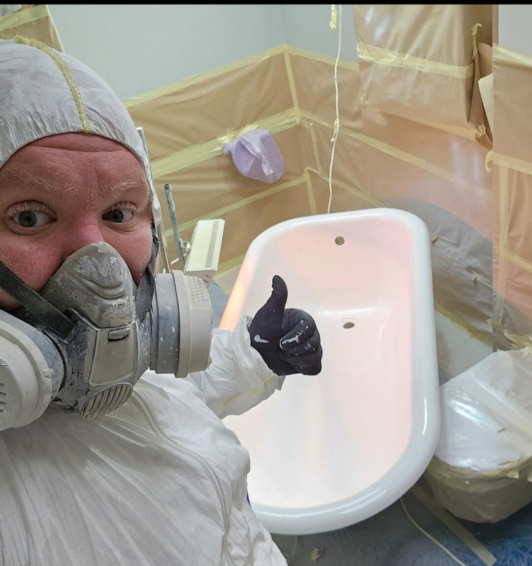 photo of glossy baths re-enamelling owner Seamus with a thumbs up, in ppe, in a room full of masking up and a completed bath in Wolverhampton